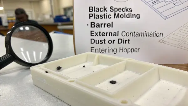 Close-up of a plastic part with a black speck impurity